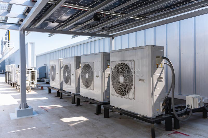 Rooftop air conditioning units installed beneath a solar panel canopy